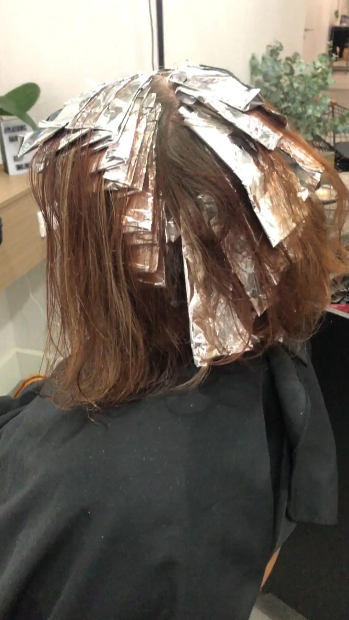 Foils in progress — wet auburn hair in silver foils